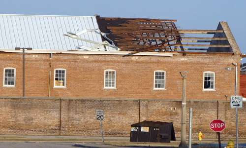Fotografia di un edificio privato del tetto a causa dell'effetto Venturi provocato da repentine raffiche di vento.